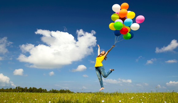 jumping in field with balloons